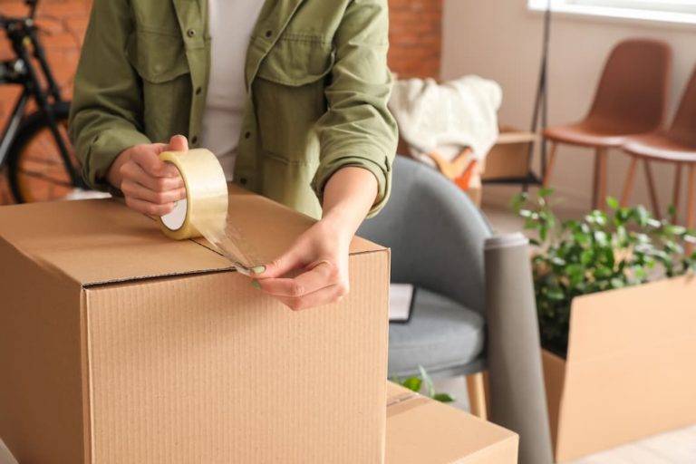 Woman Packing Moving Box At Home